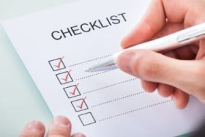 Close-up Of A Person's Hand Marking On Checklist With Pen